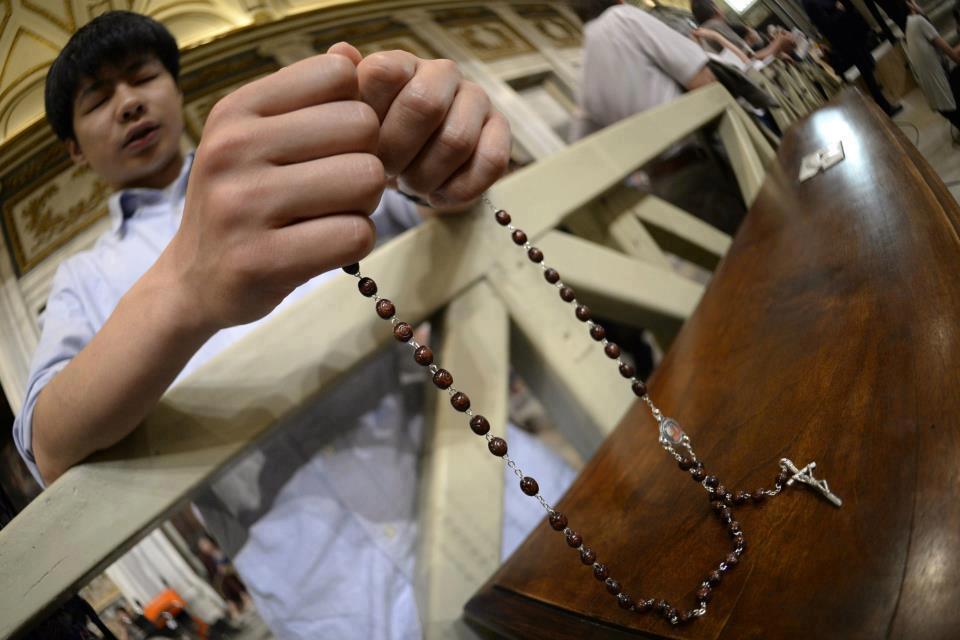 joven rezando el rosario