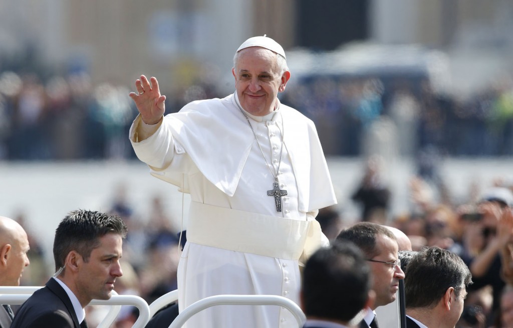 Pope Francis waves as he arrives to lead the weekly general audience in Saint Peter's Square at the Vatican
