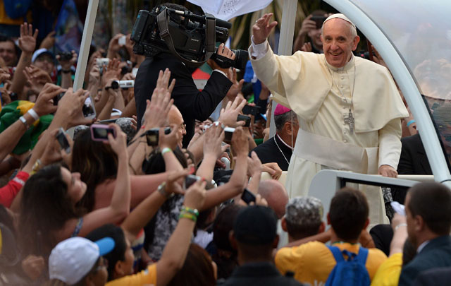 zzzzinte1Pope Francis waves at faithfuls from the popemobile on his way to the Guanabara Palace after his arrival in Rio de Janeiro on July 22, 2013. Pope Francis landed in Brazil on Monday for his first overseas trip as pontiff to attend the international festival World Youth Day in Brazil, the world's biggest Catholic country. AFP PHOTO / GABRIEL BOUYS zzzz