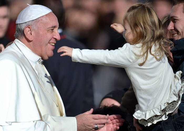 Pope Francis is about to hug a young girl during his general audience in St Peter's square at the Vatican on December 4, 2013. AFP PHOTO / FILIPPO MONTEFORTE