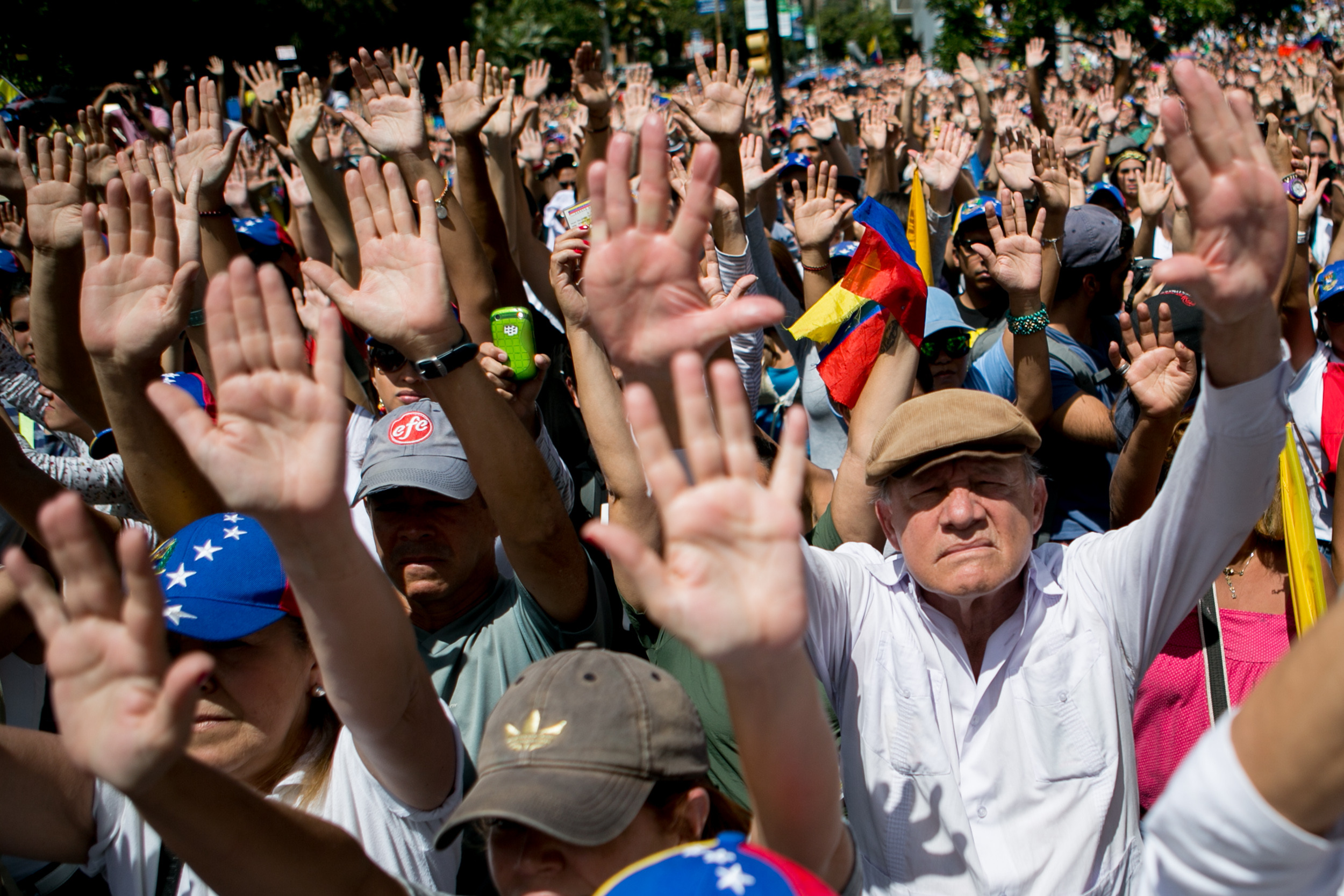 Manifestantes levantan las manos para mostrar que están desarmados y que actúan de manera pacífica durante una protesta efectuada en Caracas, Venezuela, el domingo 16 de febrero de 2013 en la que piden el desarme de grupos armados. (Foto AP/Alejandro Cegarra)